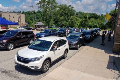 Cars lined up in street at the burger bash.