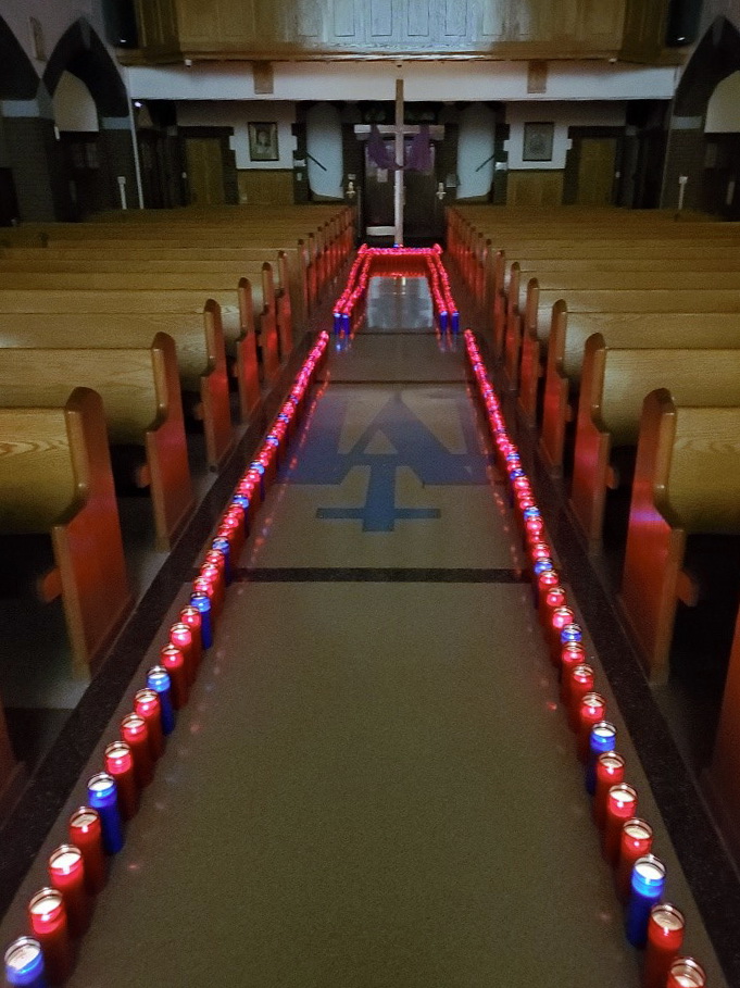 Red and blue candles lit along the main aisle of the church.